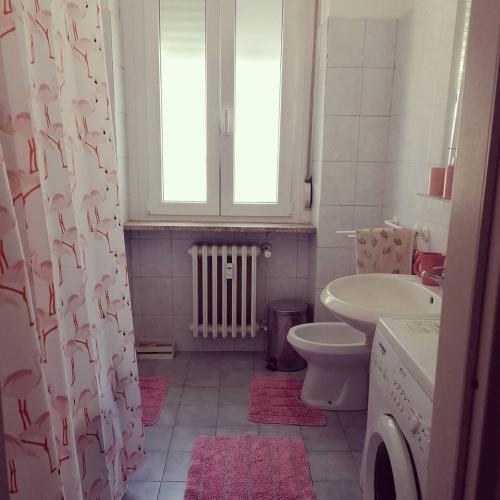 een badkamer met een wastafel, een toilet en een raam bij Il Giardino di Margherita in Turijn