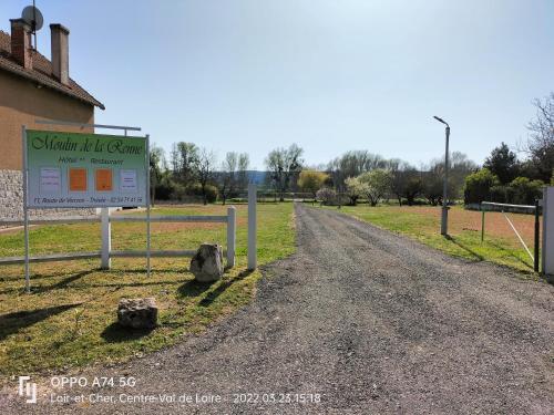 a dirt road with a sign next to a building at Hôtel Restaurant Le Moulin de la Renne Adults Only proche Zoo de Beauval in Thésée