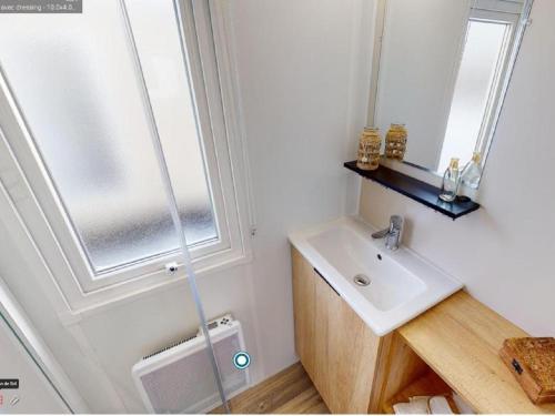 une salle de bain avec un lavabo et une fenêtre dans l'établissement Escape MobilHome aux Dunes de Contis, à Saint-Julien-en-Born