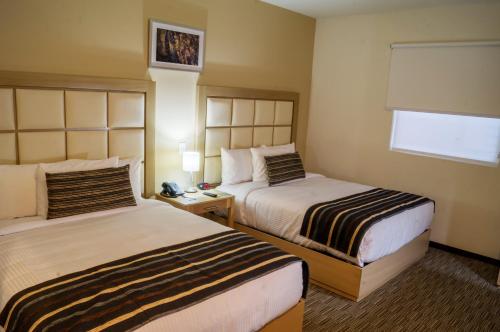 a hotel room with two beds and a window at Sleep Inn Monterrey San Pedro in Monterrey