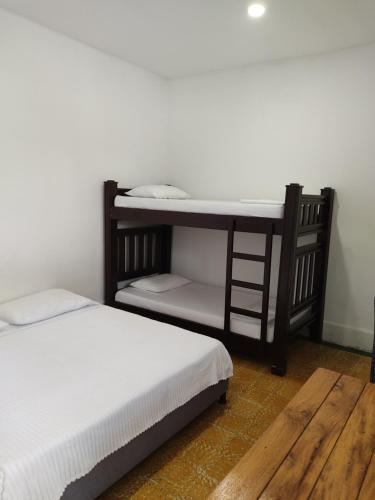 two beds in a room with a bunk bed at Hotel San Telmo in Buga