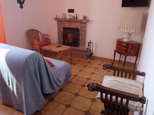 ein Wohnzimmer mit einem Bett und einem Kamin in der Unterkunft La Casa dell'Elleboro in Giustenice