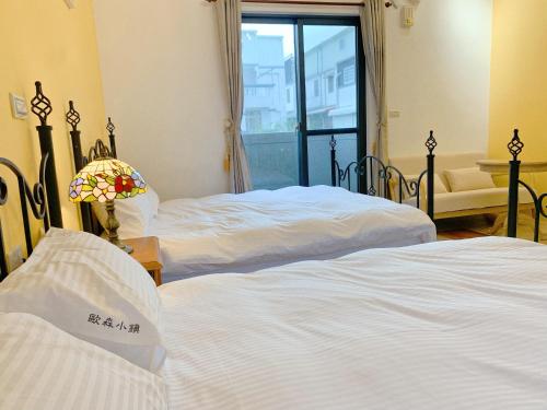 a hotel room with two beds and a window at 歐森小鎮&歐文小鎮 in Jian