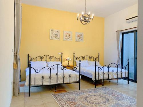 a bedroom with two beds and a chandelier at 歐森小鎮&歐文小鎮 in Jian