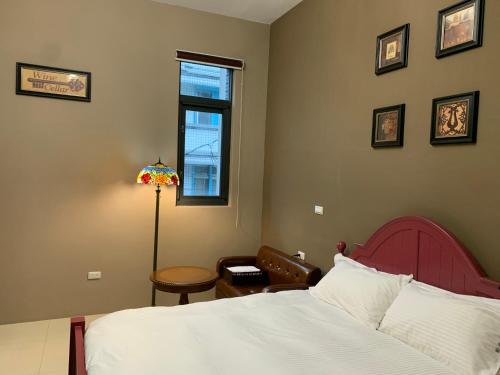 a bedroom with a bed and a chair and a window at 歐森小鎮&歐文小鎮 in Jian