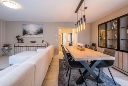 uma sala de estar com um sofá grande e uma mesa de jantar em Appartement GT em Blankenberge