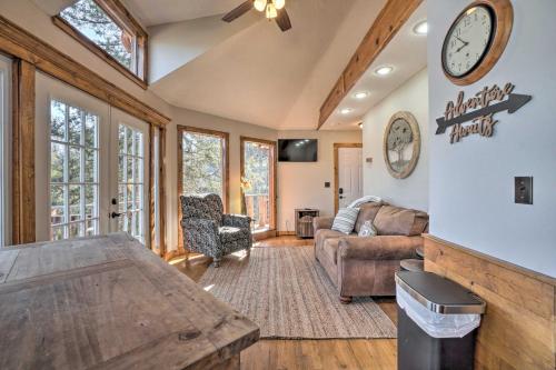 uma sala de estar com um sofá e um relógio na parede em Shell Knob Guest House with Lake View, Fire Pit em Shell Knob