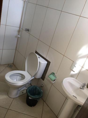 a bathroom with a toilet and a sink at Pousada Rota da Luz in Aparecida