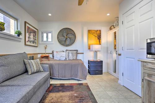 a living room with a couch and a clock on the wall at Central Elmont Studio with Great Outdoor Space! in Elmont