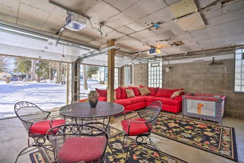 a living room with a red couch and a table and chairs at Walk to Chautauqua Lake Mayville Getaway! in Mayville