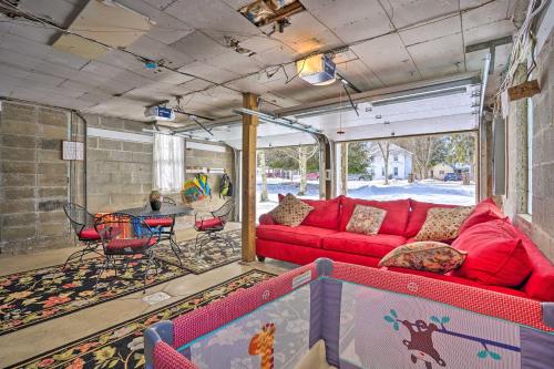 a living room with a red couch and a table at Walk to Chautauqua Lake Mayville Getaway! in Mayville