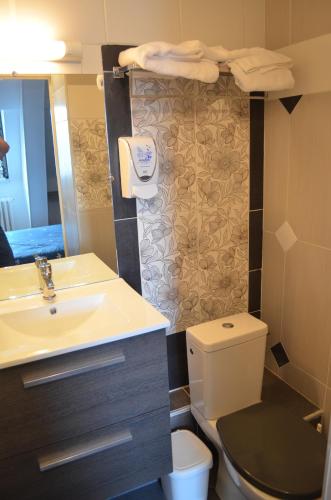 a bathroom with a sink and a toilet at Hotel Central Anzac in Amiens