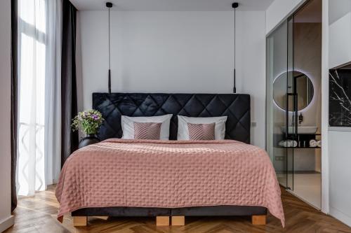 a bedroom with a large bed with a black headboard at Hotel Central Park in Poděbrady