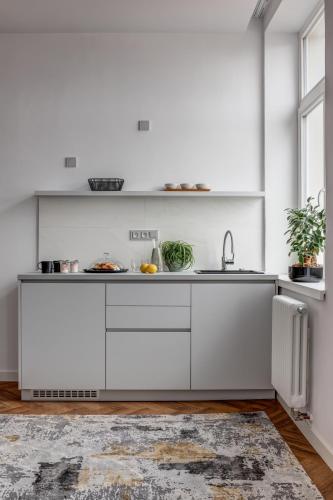 a kitchen with white cabinets and a sink at Hotel Central Park in Poděbrady