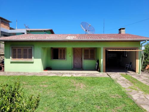 uma casa verde com uma porta e um quintal em Espaço Doméstico em Caxias do Sul