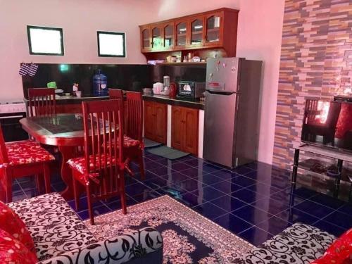 a kitchen with a refrigerator and a table and chairs at Bayabas,DigFamilyApartment Fully Furnished Near Tandag City in Somosomo