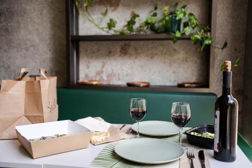 a table with a bottle of wine and two glasses at Bio Boutique Hotel XU' - Gruppo Ambienthotels in Rimini