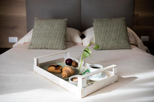 a white tray with food on a bed at Bio Boutique Hotel XU' - Gruppo Ambienthotels in Rimini