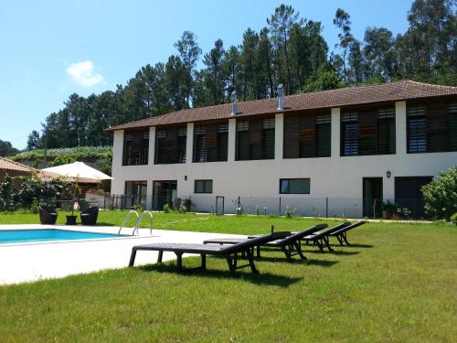 a group of benches sitting in front of a building at Casa do Engenho in Caldas de São Jorge