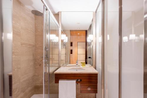 a bathroom with a sink and a shower at Eurostars Gran Valencia in Valencia