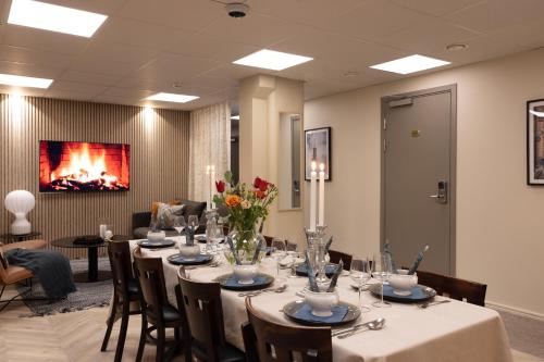 a dining room with a table and chairs and a fireplace at Hotel Söder in Stockholm