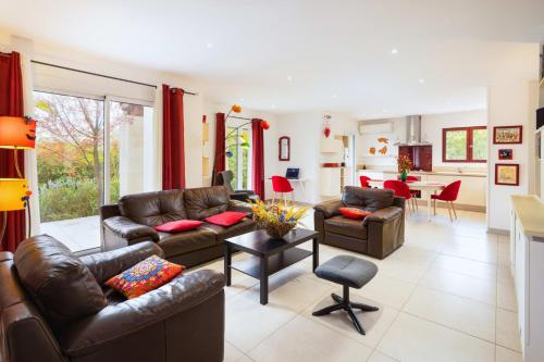 Il comprend un salon doté d'un mobilier en cuir et une cuisine. dans l'établissement Sumptuous House Of 120m With Garden And Jacuzzi, à Carcassonne