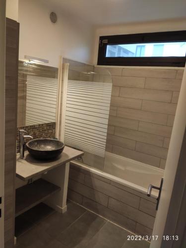 une salle de bains avec lavabo et baignoire dans l'établissement Les Tamaris, à Arles