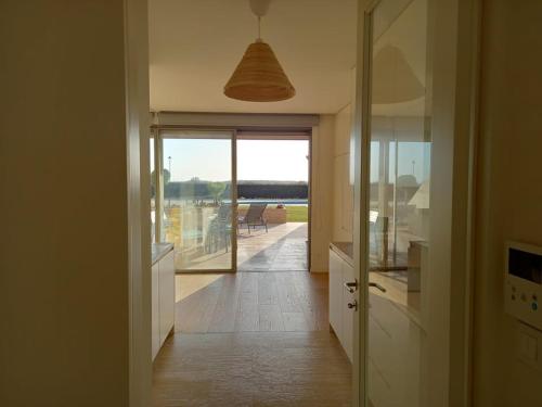 a kitchen with a hallway with a view of a balcony at Prestige & Nature Apartment in Laguna Village in Quarteira