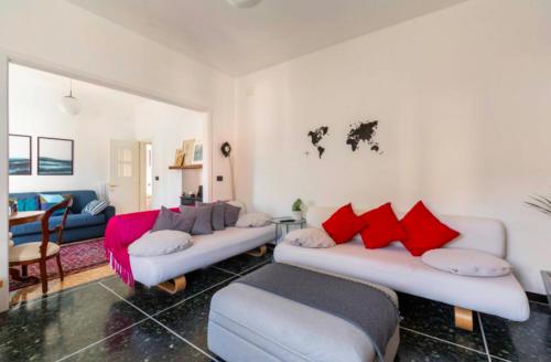 a living room with two couches and red pillows at La casa sul fiume in Albisola Superiore