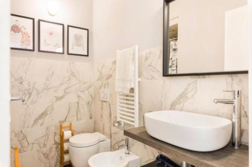 a white bathroom with a sink and a toilet at La casa sul fiume in Albisola Superiore