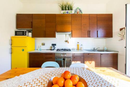 a kitchen with a table with a bowl of oranges on it at La casa sul fiume in Albisola Superiore