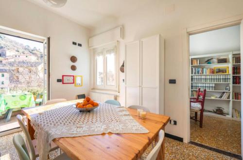 un comedor con una mesa con un tazón de naranjas. en La casa sul fiume, en Albisola Superiore
