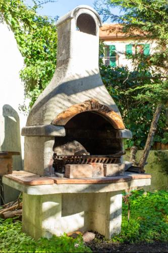 a stone pizza oven sitting in a yard at La casa sul fiume in Albisola Superiore