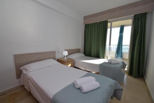 pokój hotelowy z dwoma łóżkami i oknem w obiekcie Carolina - Fincas Arena w mieście Benidorm