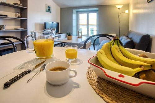 - une table avec un plateau de bananes et une tasse de jus d'orange dans l'établissement Centre-ville - calme -proche gare, à Angoulême