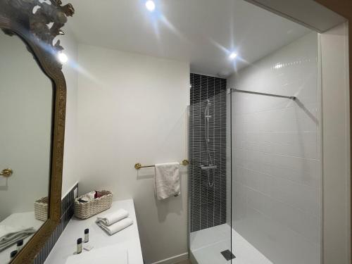 een witte badkamer met een douche en een wastafel bij Le Patio Combes de Mons in Royan