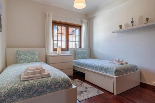 a bedroom with two beds and a window at Casa Miha in Sintra