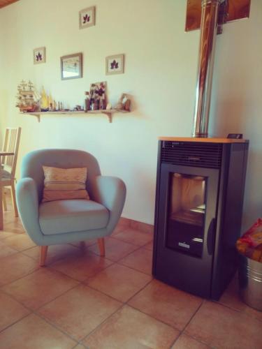 a living room with a chair and a fireplace at Villa L'Epicléa, Chorges, entre lac et montagnes in Chorges