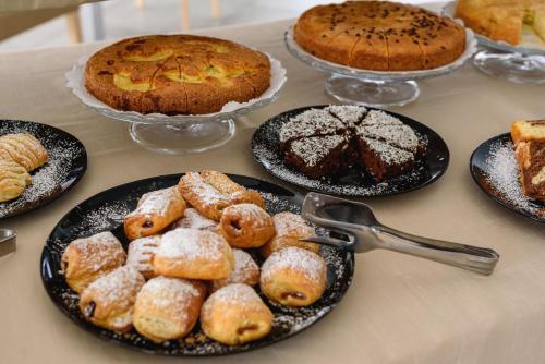 a table topped with plates of pastries and cakes at Hotel St. Giorgio in Castel San Giorgio