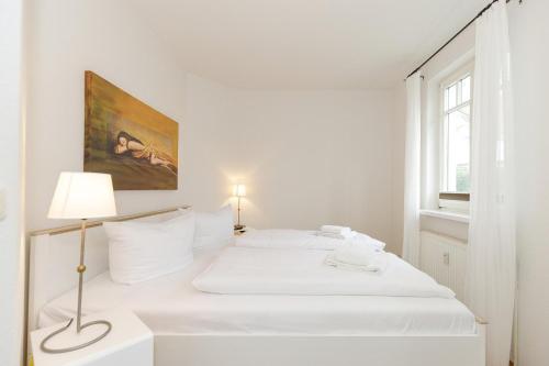屈赫隆斯博爾恩的住宿－Ulmenschlösschen Ulmenschlösschen 05，白色卧室配有床和灯