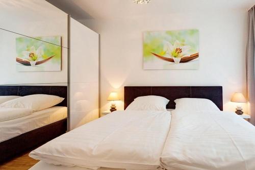 1 Schlafzimmer mit 2 Betten und 2 Gemälden an der Wand in der Unterkunft DünenResort Binz DünenResort Binz 125 in Binz