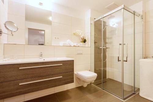 ein Badezimmer mit Toilette und Glasdusche in der Unterkunft DünenResort Binz DünenResort Binz 125 in Binz