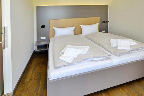 a large bed with white sheets and pillows on it at Resort Deichgraf Resort Deichgraf 31-02 in Wremen