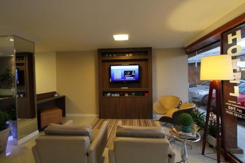 a living room with couches and a tv at Hotel Don Zepe in Florianópolis