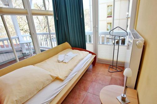 a bedroom with a bed in front of a large window at Dünenschloss Dünenschloss 1-16 in Kühlungsborn
