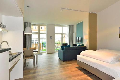a bedroom with a bed and a kitchen and a living room at Aparthotel Anna Düne Aparthotel Anna Düne 0-07 in Wangerooge
