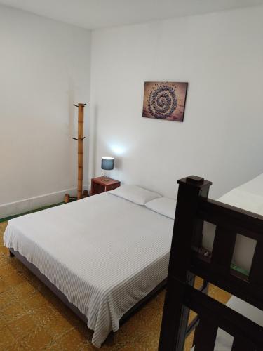 a bedroom with a bed and a picture on the wall at Hotel San Telmo in Buga