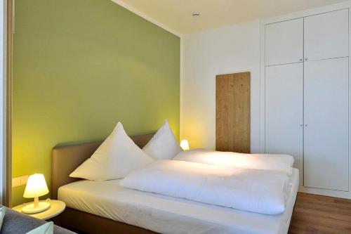 a bedroom with two beds with white pillows at Aparthotel Anna Düne Aparthotel Anna Düne 1-23 in Wangerooge