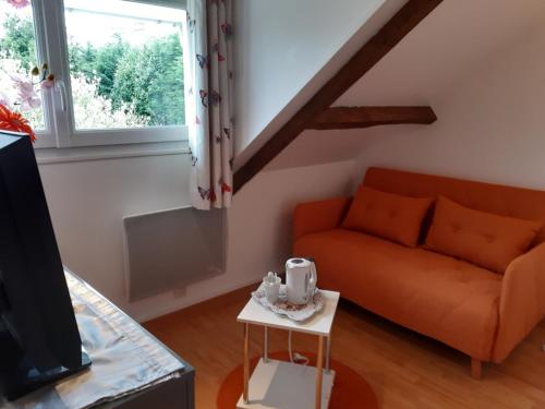 a living room with a couch and a tv at Ravissante suite.chambre d hôte in Saint-Valéry-en-Caux