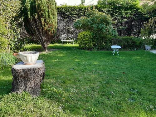 a pot on a tree stump in a yard at Ravissante suite.chambre d hôte in Saint-Valéry-en-Caux